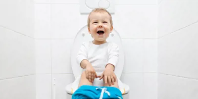 smiling child sitting on the toilet