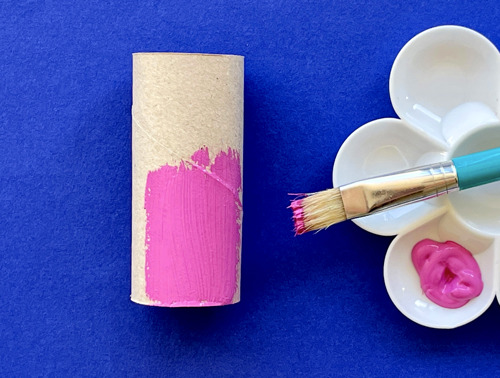 Mother and daughter at desk using toilet roll, paper and pens to make animal crafts