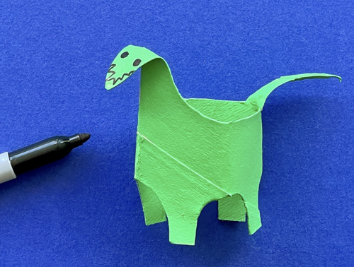 Mother and daughter at desk using toilet roll, paper and pens to make animal crafts