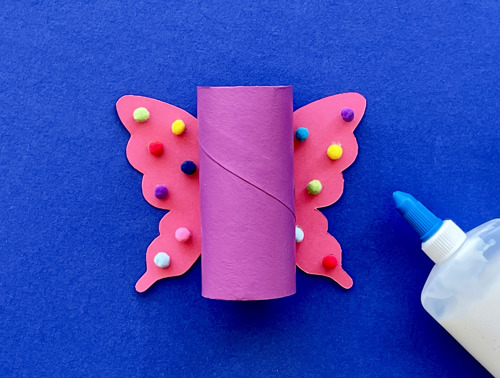 Mother and daughter at desk using toilet roll, paper and pens to make animal crafts