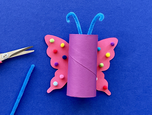 Mother and daughter at desk using toilet roll, paper and pens to make animal crafts
